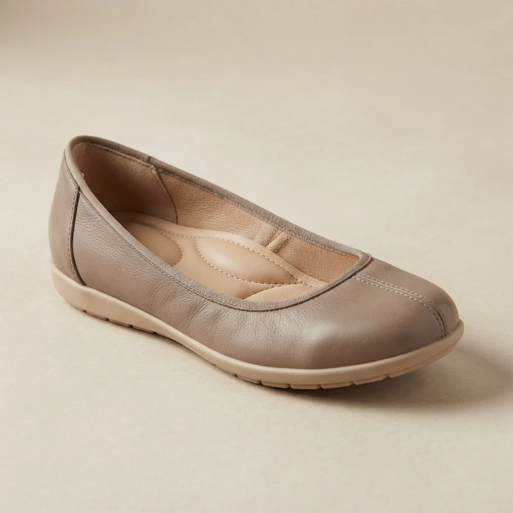 A single comfort-focused ballet flat with a visible cushioned sole on a light neutral surface